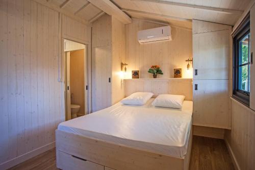 莱斯卡尔Mobil Home Confort的卧室配有一张白色大床