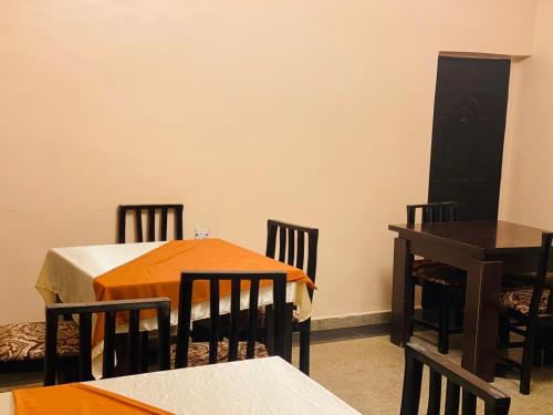 NnewiHavilah Suites Ltd, Nnewi的一间设有两张桌子和椅子的用餐室以及一扇黑色的门