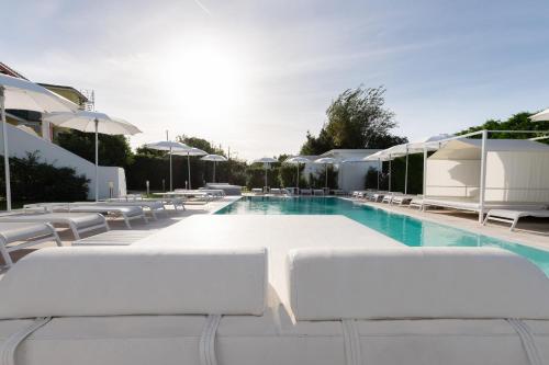 普罗奇达海狮住宿加早餐旅馆的一个带白色躺椅和遮阳伞的游泳池