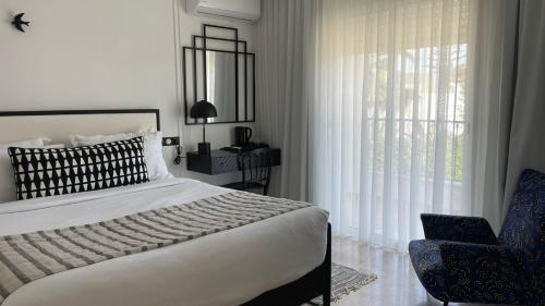 西迪·布·赛义德Misk Villa - Boutique Hotel & Spa的卧室配有床、椅子和窗户。