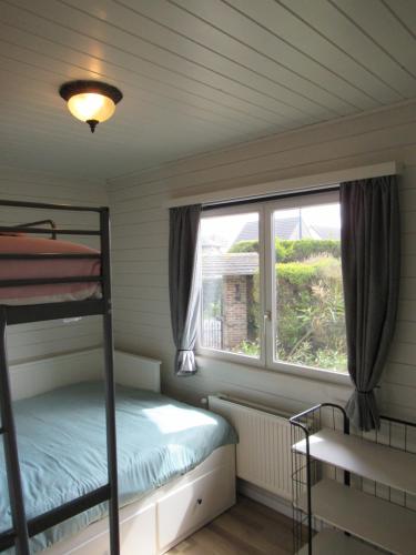KoekelareGilou的一间卧室配有双层床和窗户。