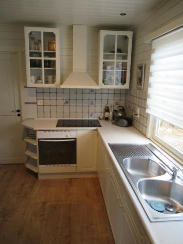 KoekelareGilou的厨房配有白色橱柜和水槽