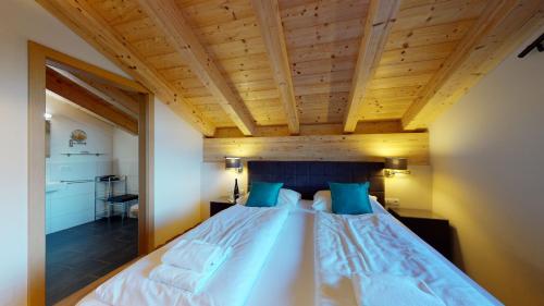 滨湖采尔Apart-Chalet Kitzblick的一间卧室设有一张带木制天花板的大床