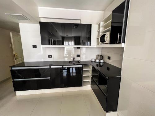 布宜诺斯艾利斯坎雷可乐塔酒店的厨房配有黑白橱柜和水槽