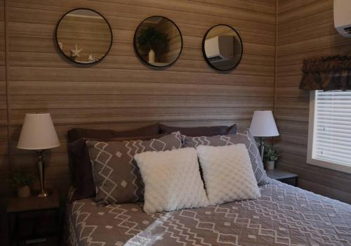 墨尔本比奇Tiny Home in Melbourne Beach的卧室配有一张带三面镜子的床铺。