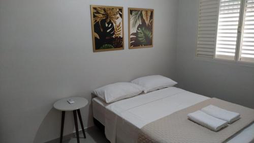 圣安热卢My House Hospedagem的一间白色的小卧室,配有床和凳子
