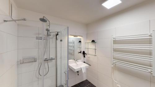 滨湖采尔Kitzview Idyll的白色的浴室设有水槽和淋浴。