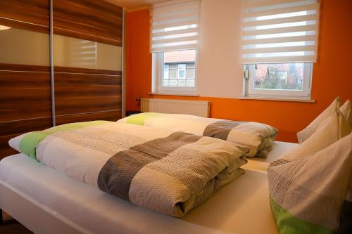 德鲁贝克Ferienwohnung Andres的橙色墙壁和窗户的客房内的一张床位