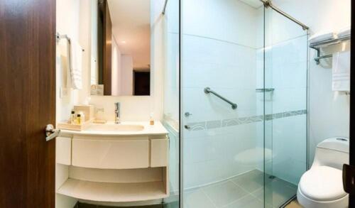 马尼萨莱斯Quo Quality Hotel的一间带玻璃淋浴和水槽的浴室