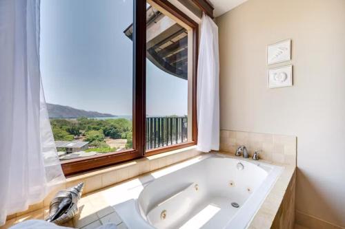 普拉亚埃尔莫萨Hermosa Vida的带窗户的浴室设有大浴缸
