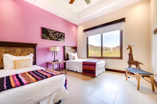 普拉亚埃尔莫萨Hermosa Vida的一间卧室设有两张床,窗户上设有一个长颈鹿
