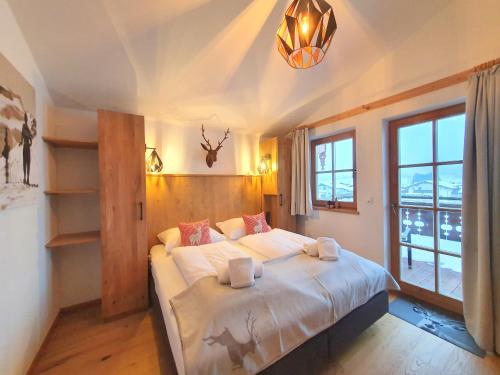 尼德恩西尔Alpen Chalets Zell am See的一间卧室设有一张床和一个大窗户