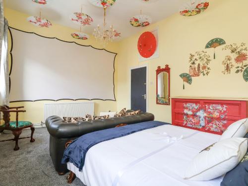 霍利韦尔The Funky Flat的一间卧室配有一张大床和红色床头板