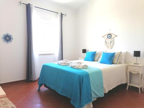 拉戈斯Marreiro's house Algarve - Child friendy - Private Pool的一间卧室配有一张带蓝色毯子的床