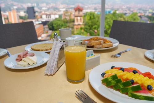 麦德林Hotel Torre Poblado的餐桌,盘子和一杯橙汁