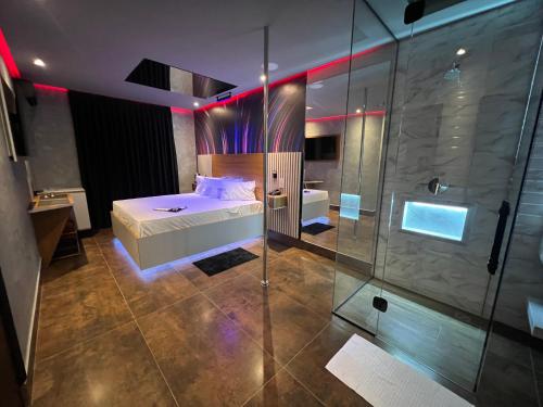 平达莫尼扬加巴Motel Prestige Pinda的一间卧室设有一张床和一个玻璃淋浴间