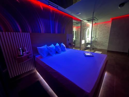 平达莫尼扬加巴Motel Prestige Pinda的一间卧室配有一张紫色灯大床