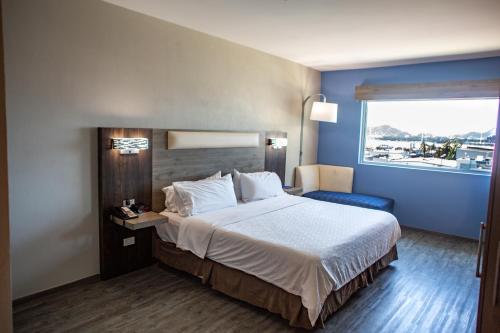 曼萨尼约曼萨尼约智选假日酒店的一间设有大床和窗户的酒店客房