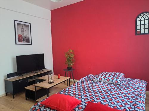普瓦捷Confortable Apart de 3 pièces的客厅设有红色的墙壁和一张床