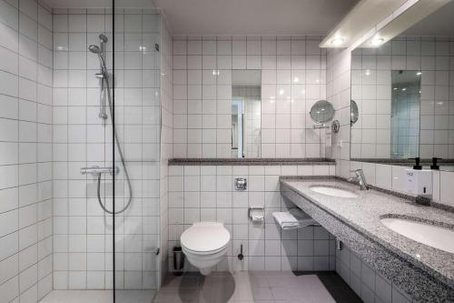 霍森斯Scandic Opus Horsens的浴室配有卫生间、两个盥洗盆和淋浴。