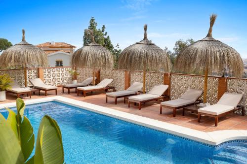 马拉加Bed & Breakfast Villa Botánica的一个带游泳池和躺椅的度假胜地