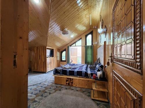 斯利那加Srinagar Group Of Hotels的卧室配有一张床铺,位于带木墙的房间内