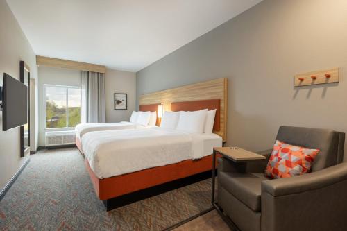 东里奇Candlewood Suites Chattanooga - East Ridge, an IHG Hotel的配有一张床和一把椅子的酒店客房