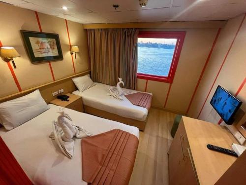 开罗Queen Isis floating hotel的酒店客房设有两张床和窗户。
