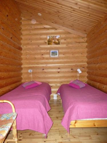 蓬卡哈尤Cottages SAA的木墙客房的两张床