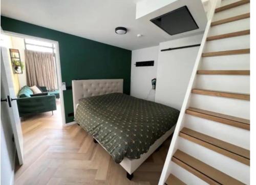 Velserbroek Cozy & Modern Tiny House的卧室在楼梯旁配有床