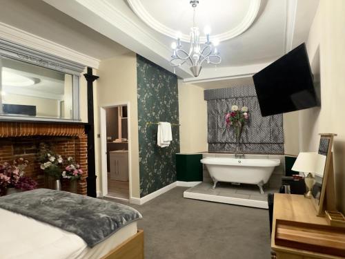 迪斯Scole Inn Hotel的带浴缸、床和电视的浴室
