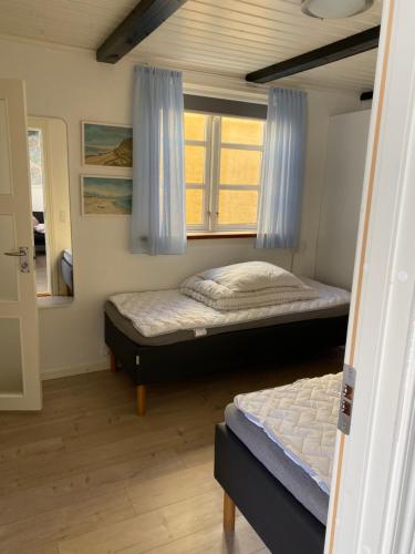斯卡恩Skagen Bo Godt Kirkevej的一间卧室设有两张床和窗户。