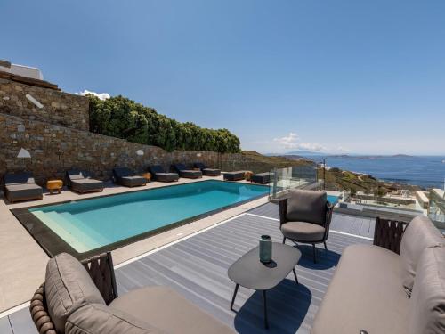 法纳里Gorgeous Mykonos Villa | 4 Bedrooms | Villa Atalanta | Private Pool & Panoramic Sea Views | BBQ | Faros的一个带游泳池和庭院的别墅