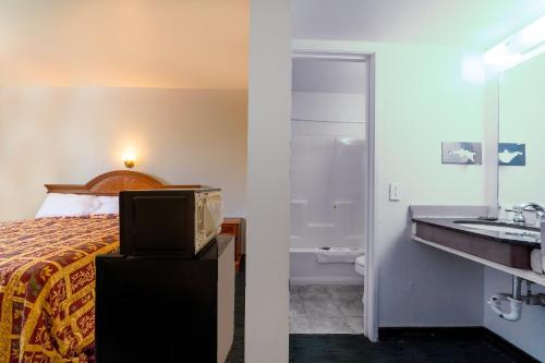 奇克谢Castle Inn & Suites By OYO Chickasha的一间酒店客房 - 带一张床和一间浴室