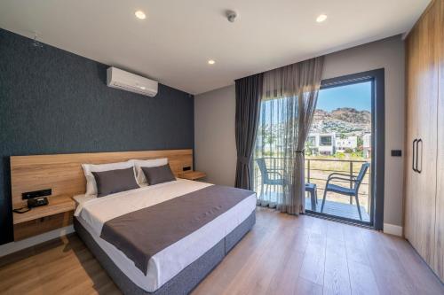 博德鲁姆Gündoğan Suites的一间带大床的卧室和一个阳台