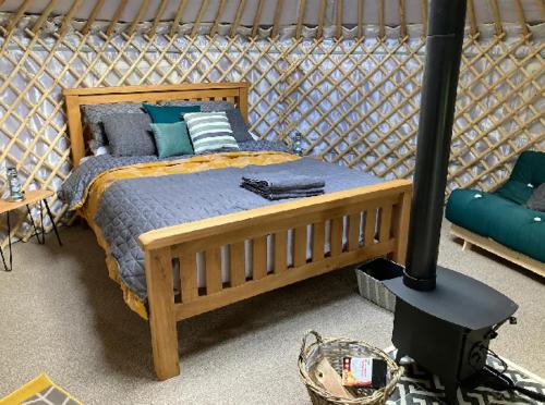 约克Eisa Yurt的一间卧室配有木床和燃木炉