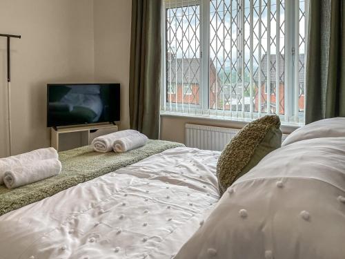StaveleyHarris House的一间卧室设有一张床、一台电视和一个窗口。