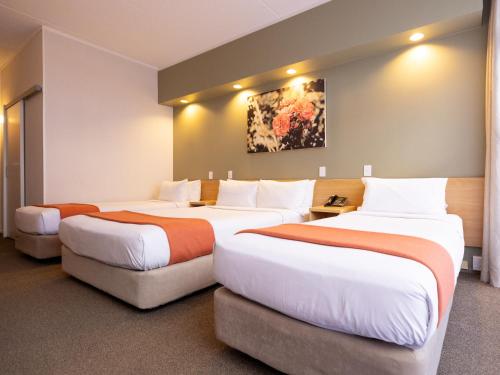 奥克兰奥克兰玫瑰园酒店的一间酒店客房,房间内设有三张床