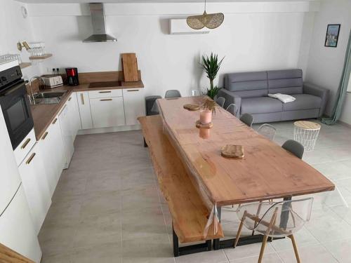 ChoussyLe Pressoir Macy - Terracobois的厨房以及带木桌的起居室。