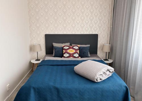 哈米纳Hamina City Apartments的一间卧室配有一张带两盏灯的蓝色床。