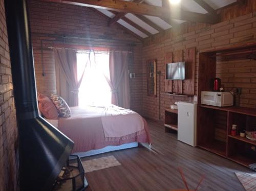 坎巴拉Chalés Corucacas的一间卧室设有一张床和一个窗口