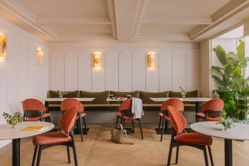 尼斯Yelo Mozart powered by Sonder的一间餐厅,房间内设有橙色椅子和桌子