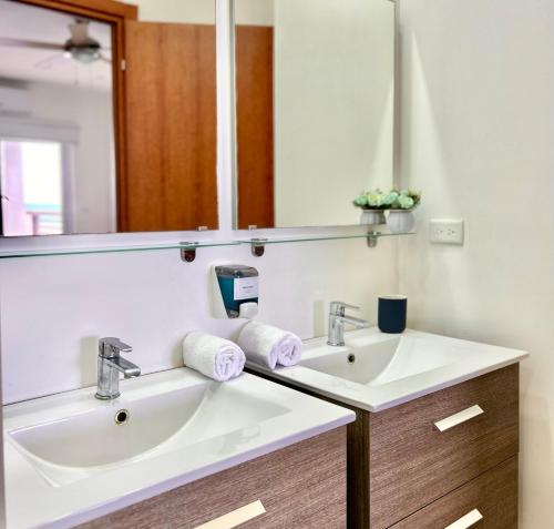 罗阿坦Condominio 2 habitaciones frente al mar的浴室设有2个水槽和镜子