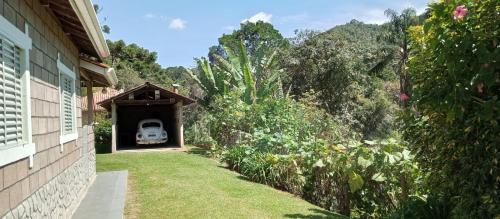 贡萨尔维斯Canto dos Pássaros- Casa de campo em Gonçalves的一辆汽车在院子里从车库里伸出来