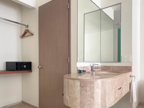 图卢姆Siente Tulum的一间带大理石水槽和镜子的浴室