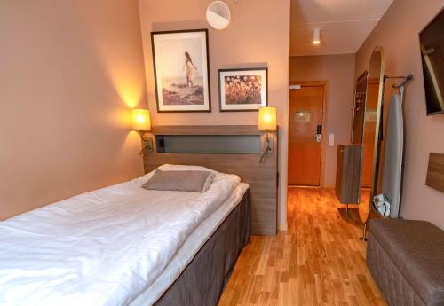 哥德堡斯堪迪克皇冠酒店的一间卧室配有一张大床和一张沙发