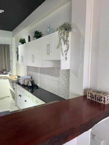 劳托卡“Marley’s Home“的厨房配有白色橱柜和木制台面