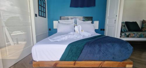 DucosLa villa Tina的卧室配有白色床和蓝色的墙壁