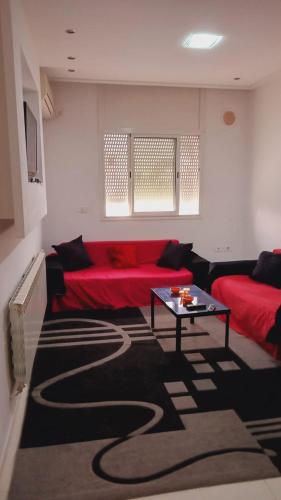 Chott MeriemKalthoum的客厅配有红色的沙发和桌子