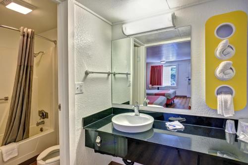 费耶特维尔费耶特维尔6号汽车旅馆的一间带水槽和镜子的浴室